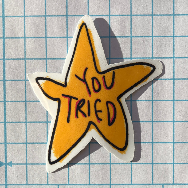 Star-shaped sticker with 'YOU TRIED' text on a grid background