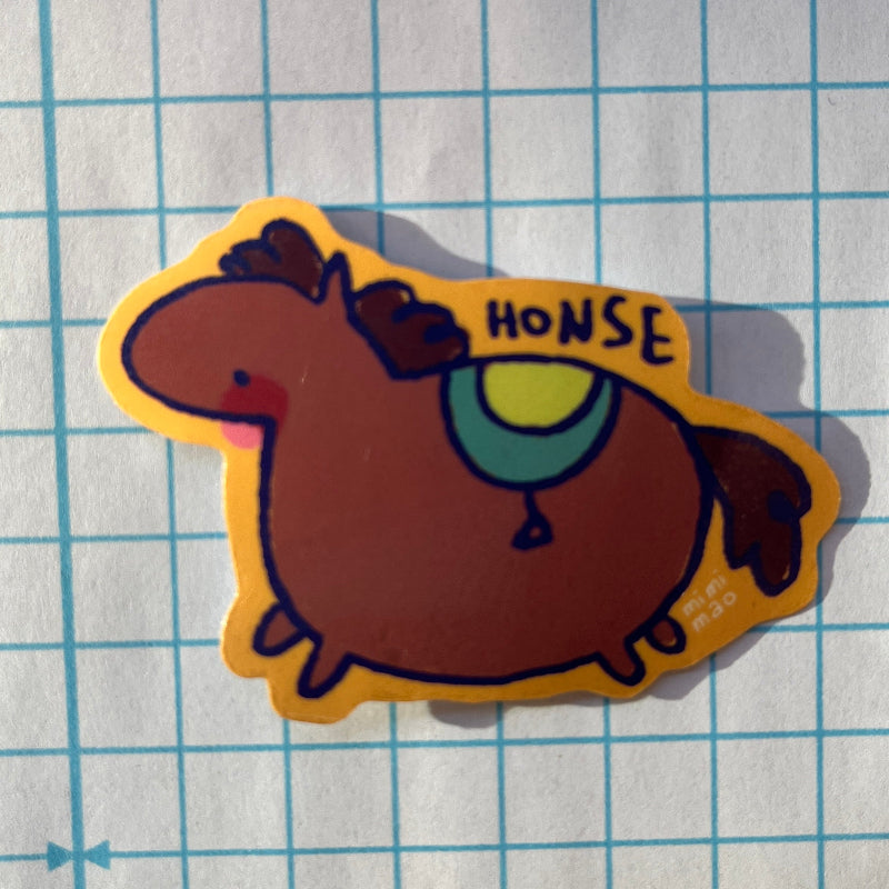 Cartoon horse sticker with 'HONSE' text on a grid background