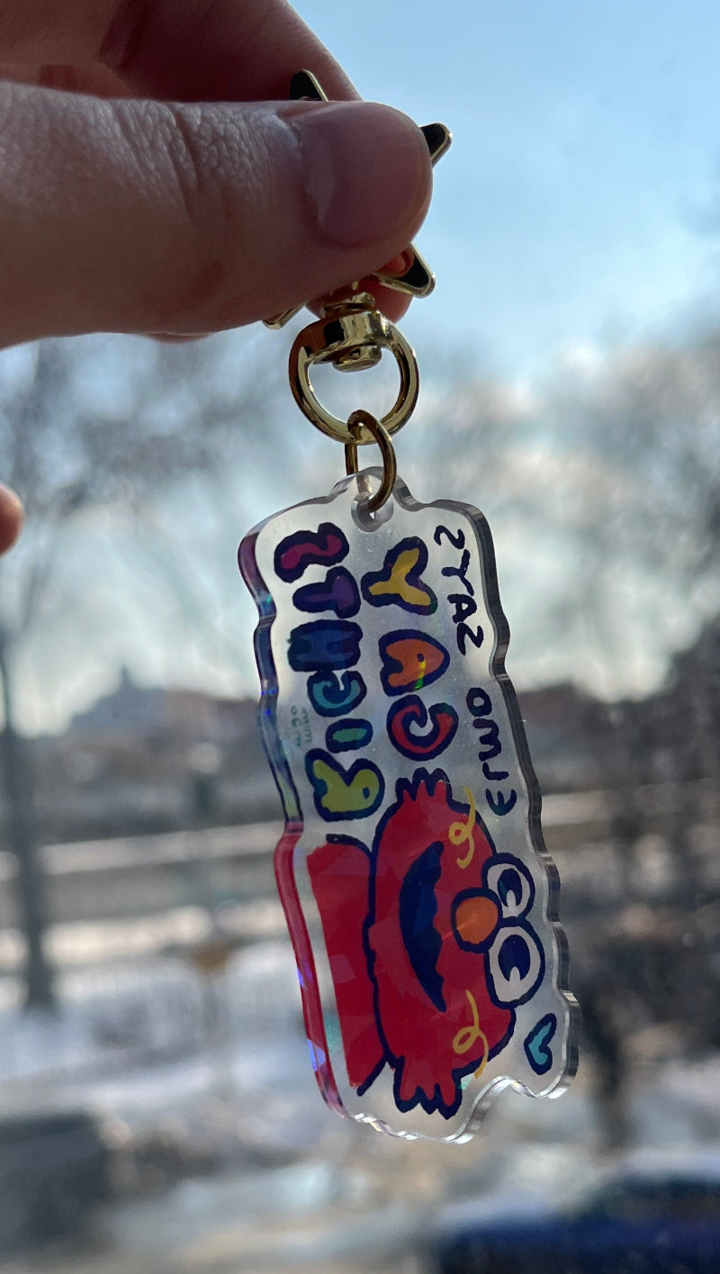 Keychain with a cartoon character held in front of a reflective surface