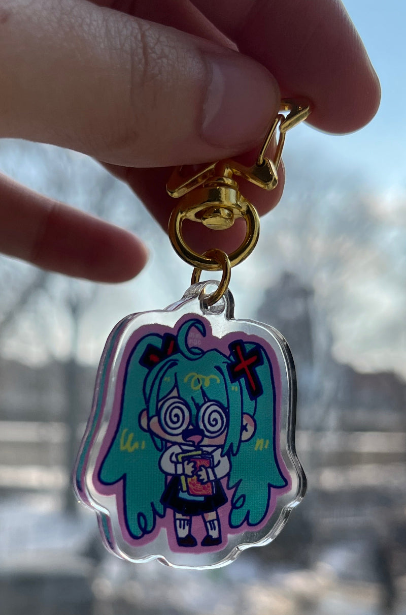Hand holding a colorful keychain with a cityscape in the background